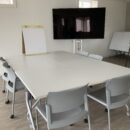 Training room with large table, easel, and large monitor.